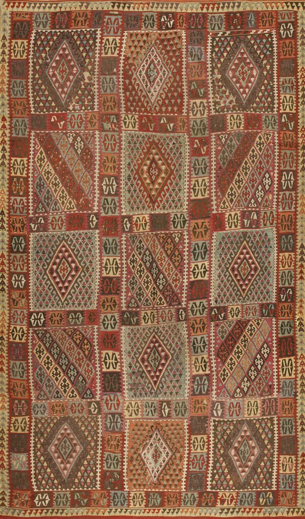 Complex flatweave rug displaying geometric squares filled with diamonds, utilizing rich reds and muted earth tones.