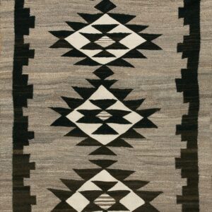 Gray flatweave rug with stacked black and white serrated diamond medallions and a dark stepped border.