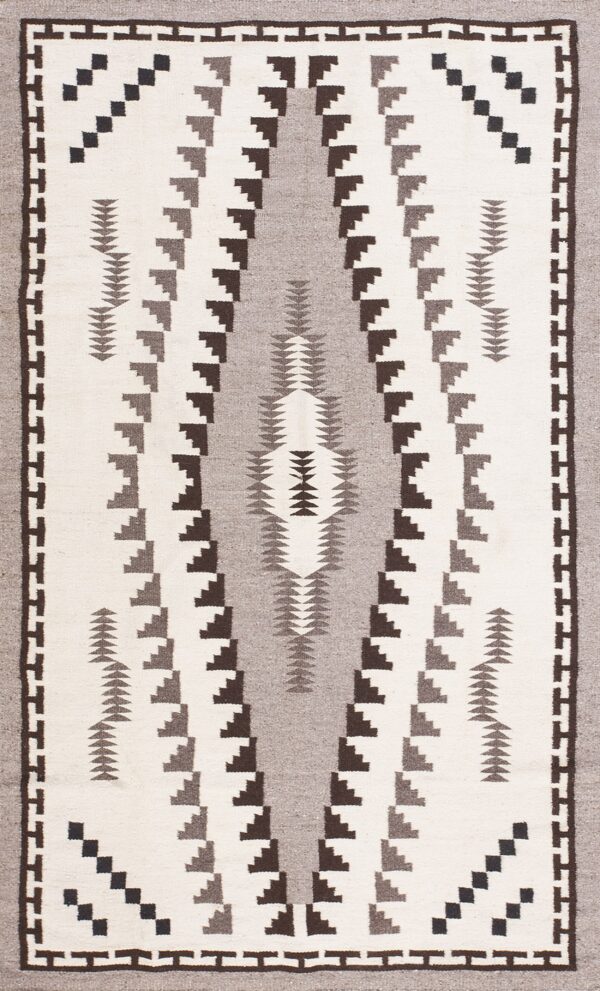 White, gray, and dark brown flatweave rug with stepped geometric tribal patterns.