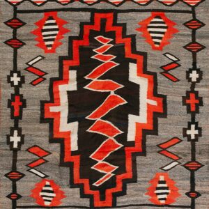 Geometric flatweave rug in gray, black, red, and white with a central serrated vertical design.