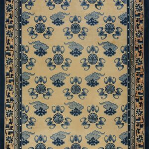 Beige rug featuring repeating dark blue cloud and bat motifs with complex borders in blue and tan.