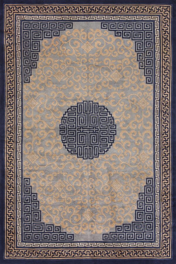 Navy blue bordered rug with a gray field, gold scrolling patterns, and a central fretwork medallion.