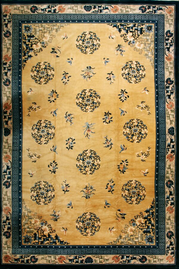 Golden yellow rug with scattered blue florals, flanked by complex blue and tan decorative borders.