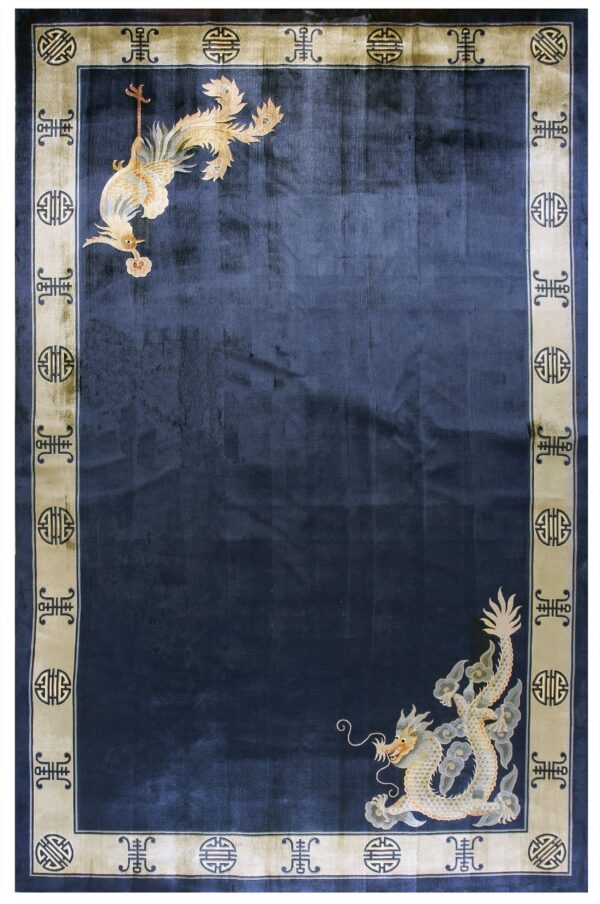 Dark blue rug with corner dragon and bird motifs contrasting a beige border with geometric symbols.