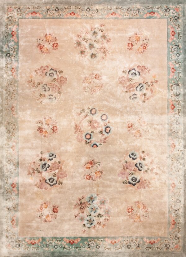 Vintage light cream color european influenced florals luxurious silk pile chinese room size rug 1 A distressed beige rug features scattered floral clusters and a wide pale sage green floral border.