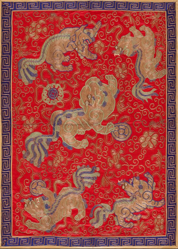 Decorative red textile with gold embroidered mythical beasts, teal accents, and a blue geometric border.