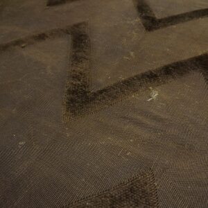 Brown high-low pile rug featuring a dark zigzag pattern over a textured background.