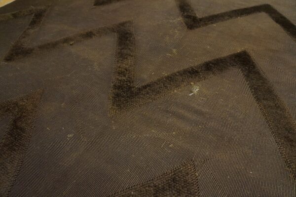 Brown high-low pile rug featuring a dark zigzag pattern over a textured background.