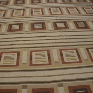 Geometric flatweave rug featuring alternating bands of stripes and rectangular brown, rust, and beige motifs.