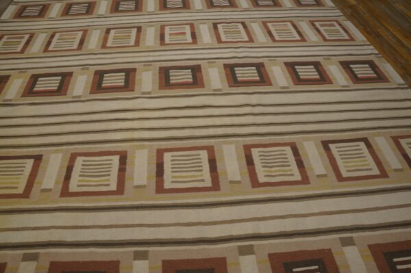 Geometric flatweave rug featuring alternating bands of stripes and rectangular brown, rust, and beige motifs.