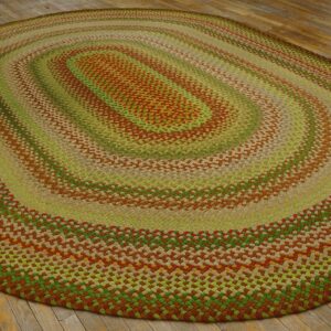 Braided oval rug with concentric rings of lime green, rust brown, and tan on aged wooden flooring.