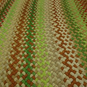 A tightly braided rug surface shows diagonal stripes in shades of green, beige, brown, and reddish tones.