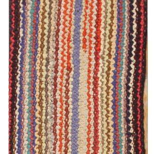 Low-pile braided runner rug in an oval shape, showing concentric multicolored stripes of red, blue, tan, and brown.
