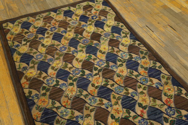 Runner rug with a beige floral ribbon and blue/brown striped lattice pattern on a light wood floor.