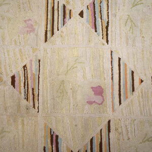 Cream shag rug detail showing striped geometric shapes and subtle pink and green floral motifs.