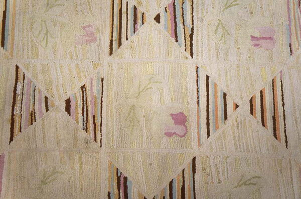 Cream shag rug detail showing striped geometric shapes and subtle pink and green floral motifs.