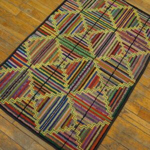 Rectangular low-pile rug featuring a vibrant, striped geometric pattern with yellow outlining on wood planks.