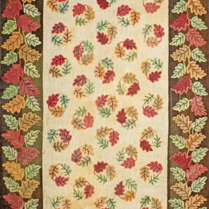 Hooked rug with multicolored autumn leaves bordering a beige field scattered with leaf clusters.