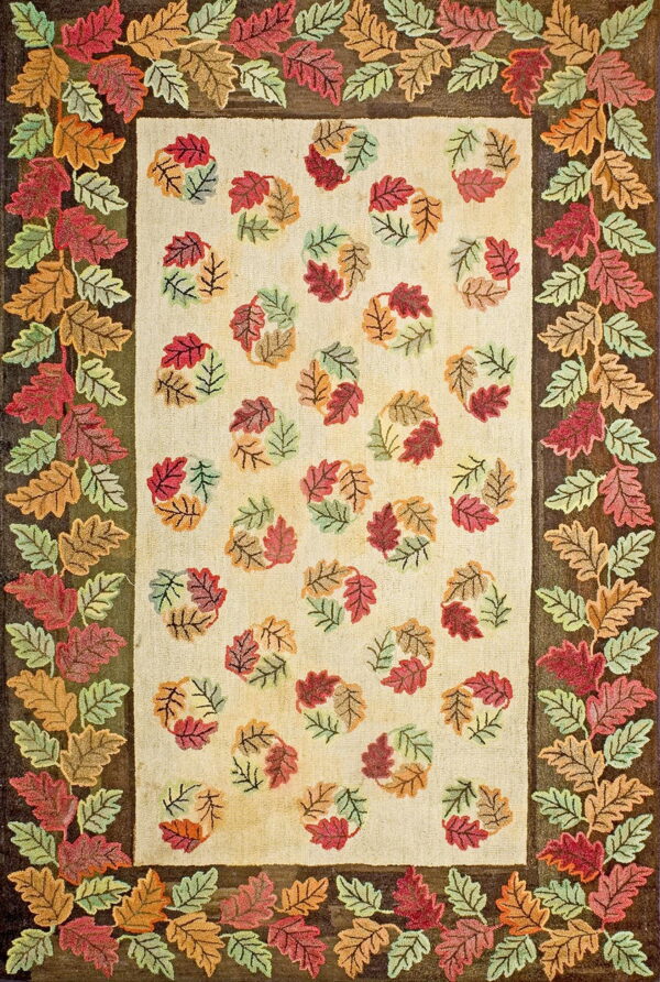 Hooked rug with multicolored autumn leaves bordering a beige field scattered with leaf clusters.