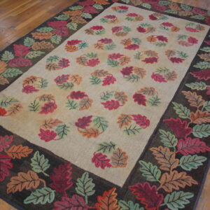 Rectangular rug with a dark border and a colorful autumn leaf pattern on a light beige ground.