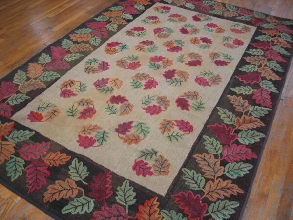 Rectangular rug with a dark border and a colorful autumn leaf pattern on a light beige ground.