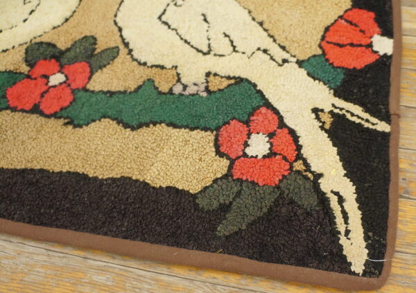 Low-pile looped rug featuring red flowers, green vines, and a white figure outline on a wood floor.