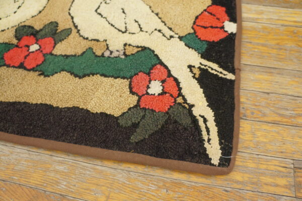 Highly textured rug with white birds, red flowers, and green leaves resting on worn wood flooring.