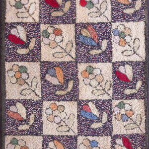 Multicolor, textured rug with a checkerboard design of stylized flowers on cream and dark speckled squares.