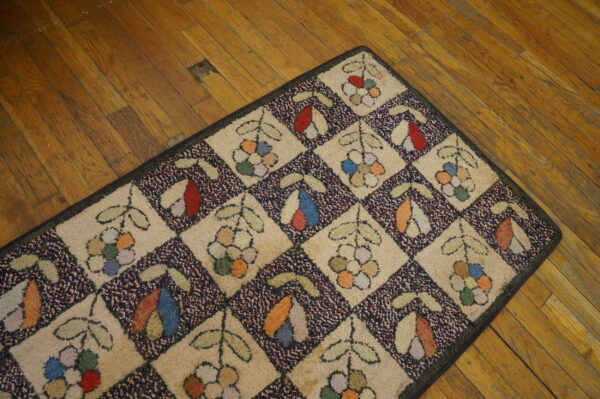 Multicolor textured rug featuring a botanical diamond pattern with tan and speckled navy sections on hardwood flooring.