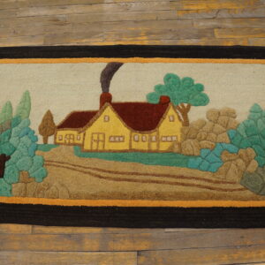 Hooked rug featuring a colorful country scene with a yellow house and green foliage on wooden floors.