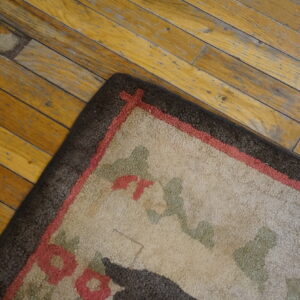 A high-pile beige rug with red, green, and dark brown patterns rests on a distressed yellow wood floor.