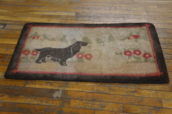Beige textured rug featuring a brown dog silhouette, green foliage, and red floral accents on worn wood planks.