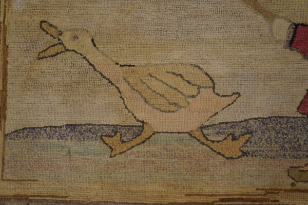 Chunky hooked rug section featuring a beige and yellow duck figure on a mottled purple and tan background.