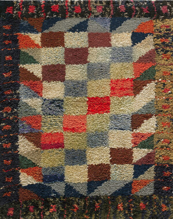 Shaggy, multicolored rug with a central square checkerboard pattern and geometric block borders.