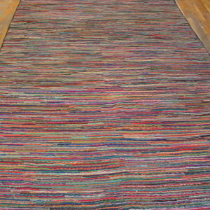 A multicolored striped runner rug lies on light brown hardwood flooring.