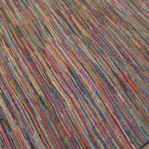 Textured multicolor rug with narrow diagonal stripes resting on a light wooden floor.