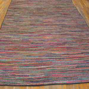 A long, multicolored striped runner rug with visible texture lies on a glossy wood floor.
