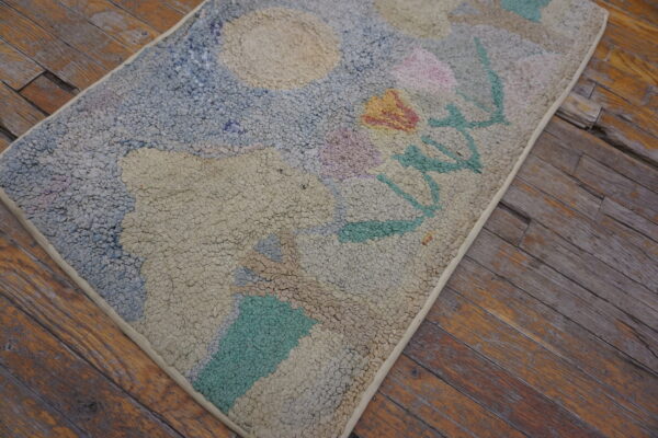 High-pile abstract rug with pale blue, beige, and pastel accents rests on weathered plank flooring.