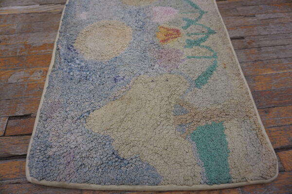 Abstract pastel looped rug with chunky texture in cream, blue, and green on wood planks.