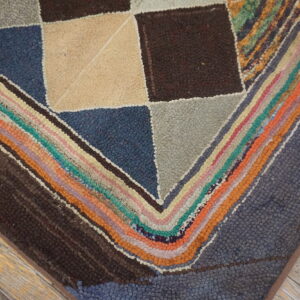 Nubby rug featuring large geometric squares and multicolor concentric stripes on distressed wood planks.