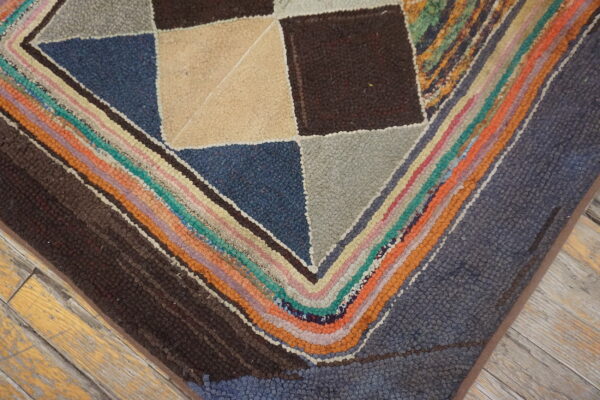 Nubby rug featuring large geometric squares and multicolor concentric stripes on distressed wood planks.