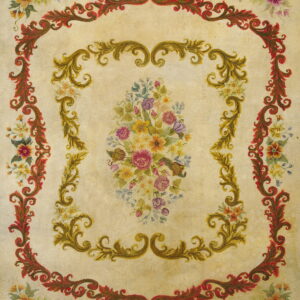 Ornate pale yellow rug with red and gold scroll borders framing a detailed multicolor floral design.