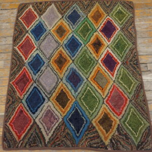 Multi-colored, textured diamond pattern rug with shades of red, blue, green, and orange on old wood planks.