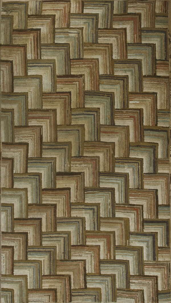 Textured rug featuring a staggered geometric pattern of brown, tan, sage green, and muted blue l-shapes.