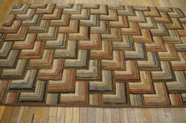 Chunky looped rug with a multi-colored zigzag pattern in earthy tones, resting on rustic wood floors.