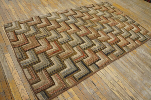 Geometric textured rug in variegated brown, tan, orange, and blue zigzags rests on light wood planks.
