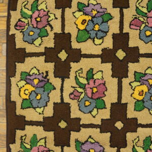 Close-up of a shaggy rug featuring colorful floral bouquets within a brown and tan geometric grid on wood floors.