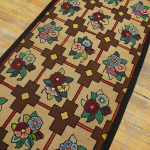 Tan runner rug with a multicolored floral and geometric brown cross pattern on light wooden planks.