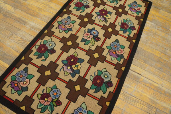 Tan runner rug with a multicolored floral and geometric brown cross pattern on light wooden planks.