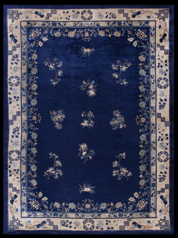 Deep blue high-pile rug with scattered floral patterns and a wide cream-colored geometric border.